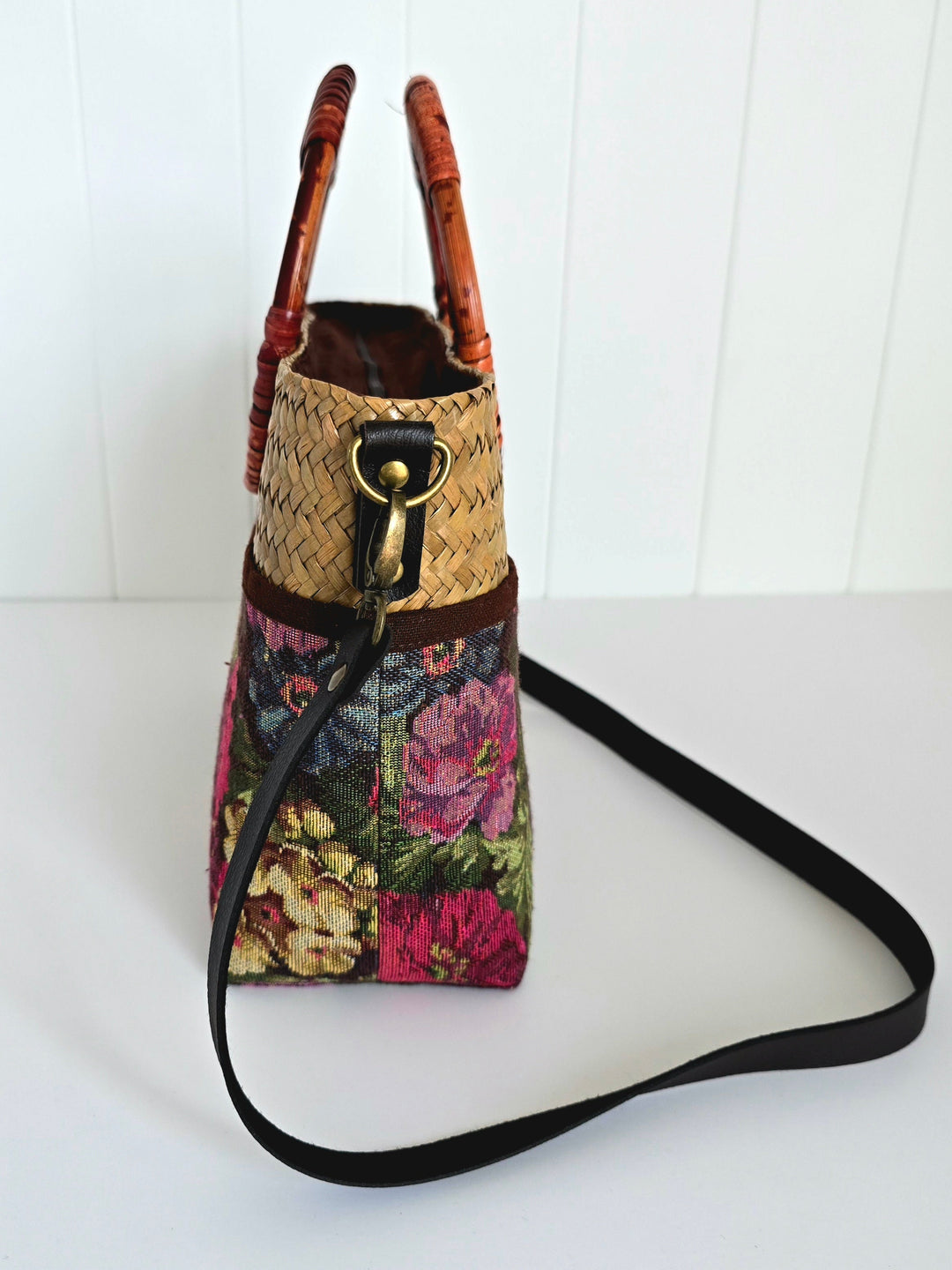 Handbag with floral pattern and woven top on a white background