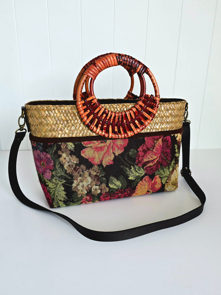 Floral-patterned handbag with woven handle on a white background