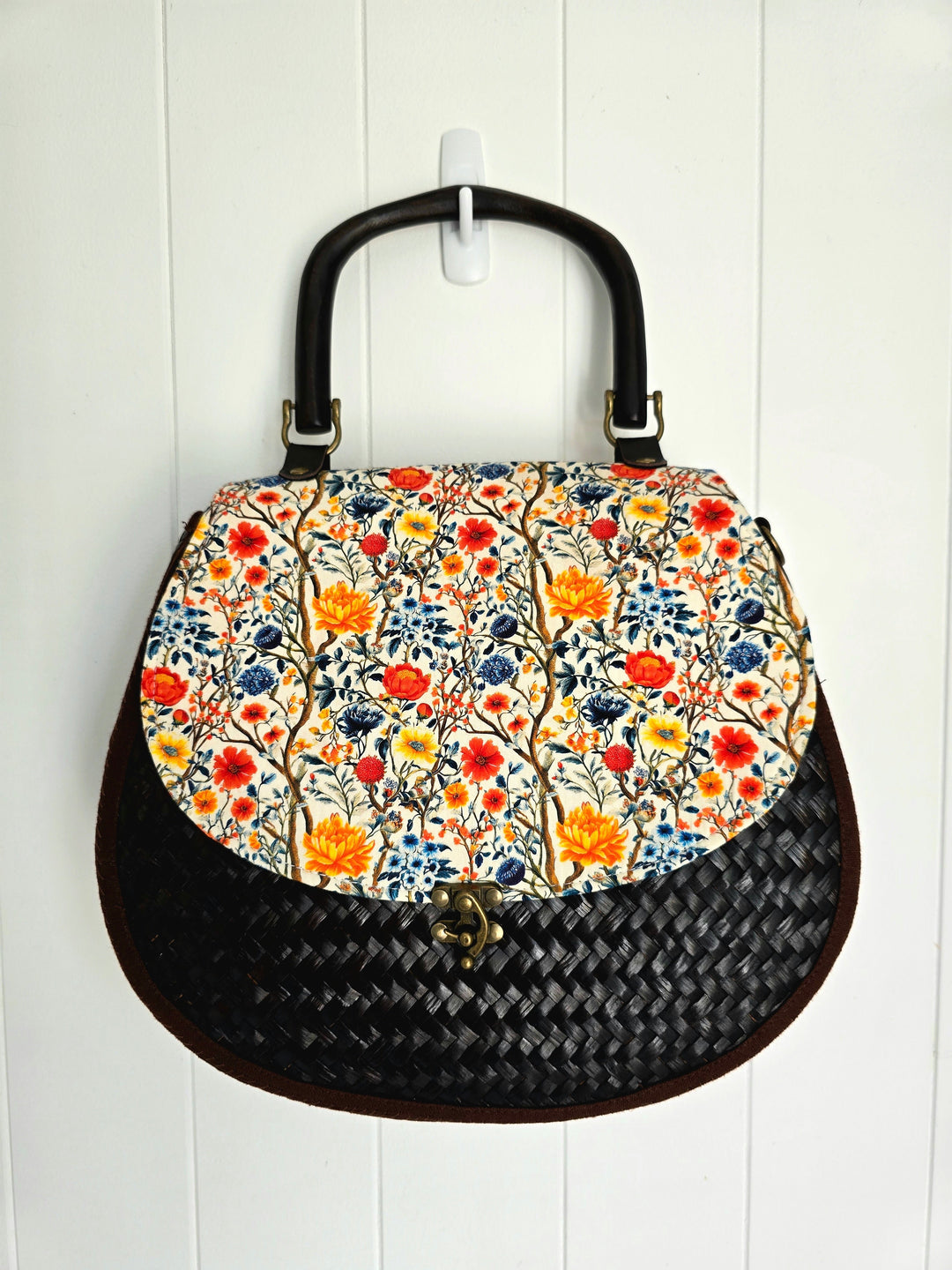 Handbag with floral pattern and woven texture on a white background
