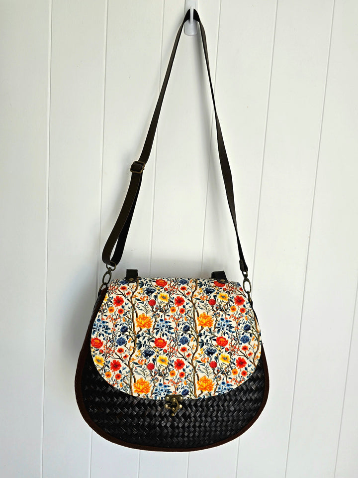 Handbag with floral pattern on a white wooden background