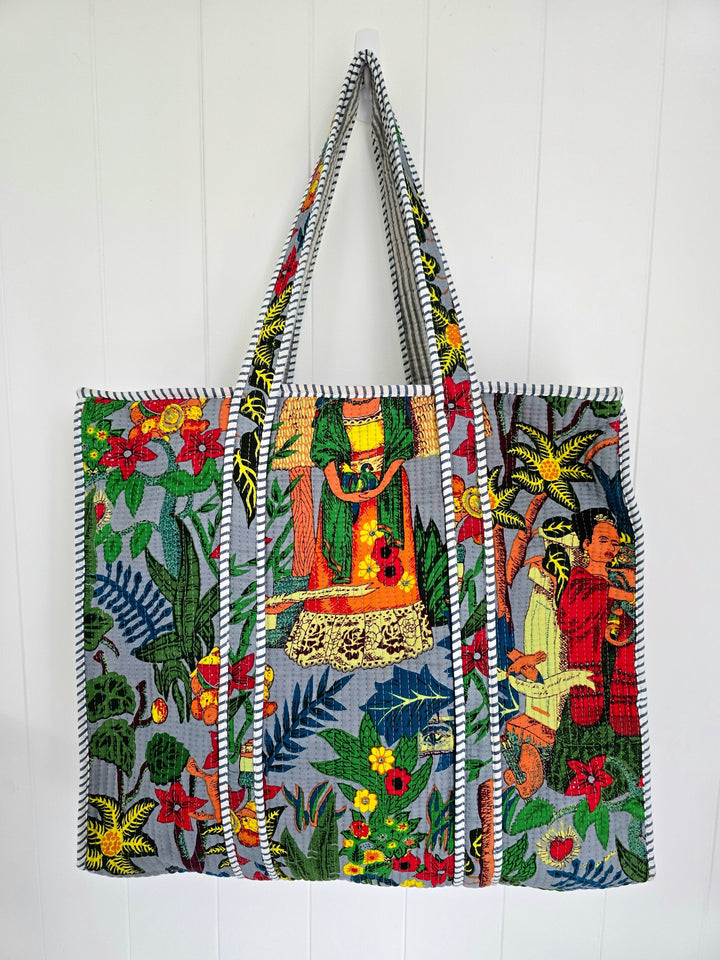 Colorful embroidered tote bag with floral and figurative patterns on a white background