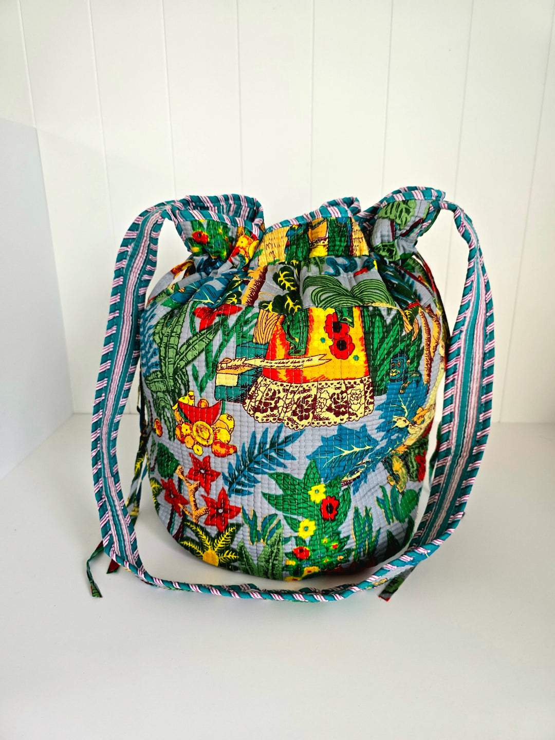 Colorful drawstring bag with tropical design on a white background