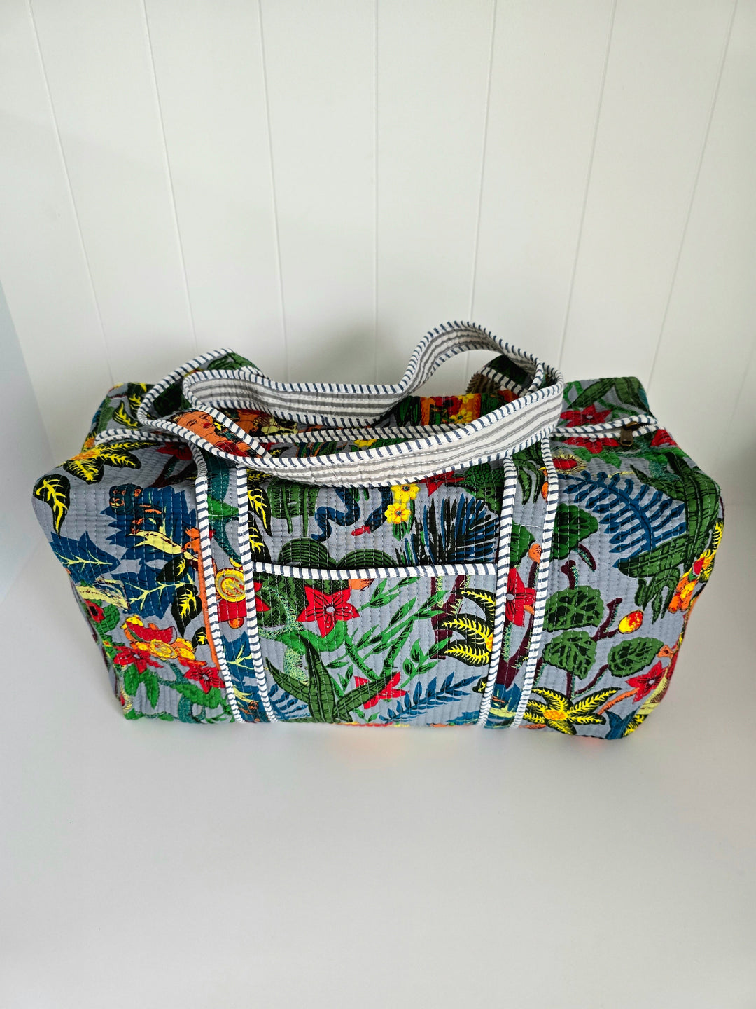 Colorful fabric bag with a tropical pattern on a white background