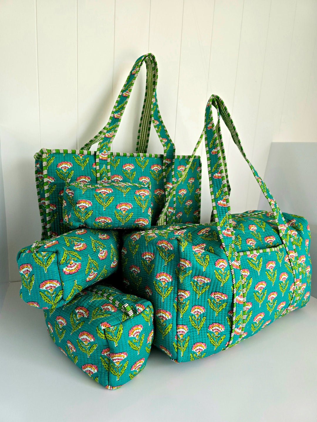 Set of teal bags with floral pattern on a white background