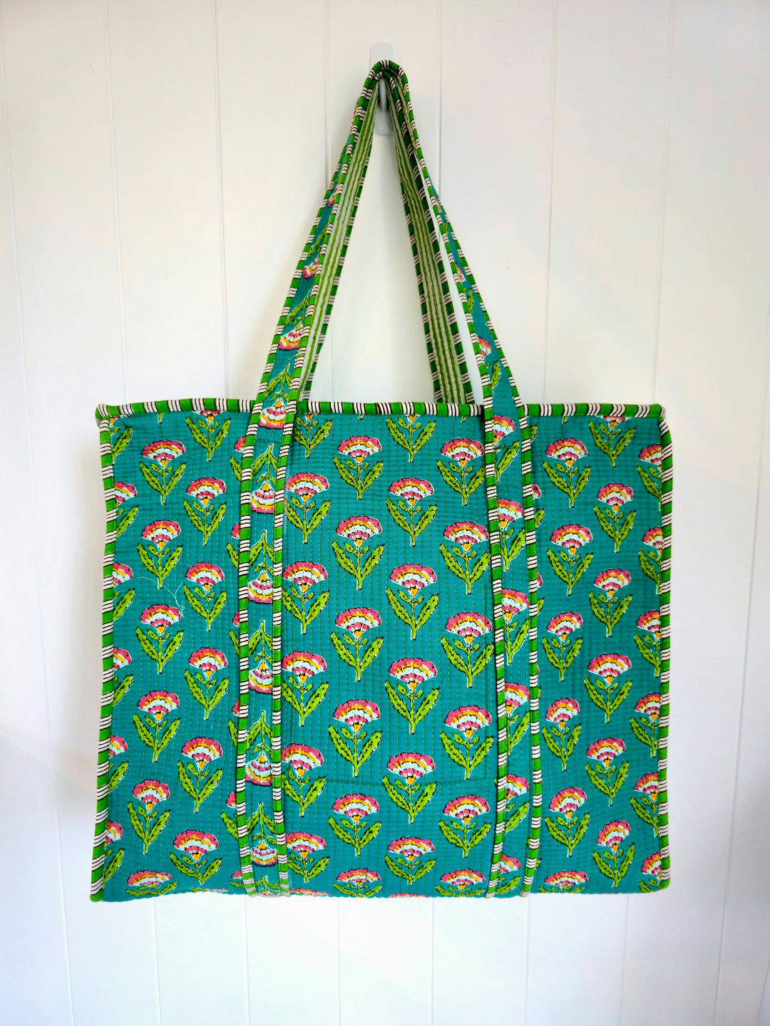 Green tote bag with floral pattern on a white background
