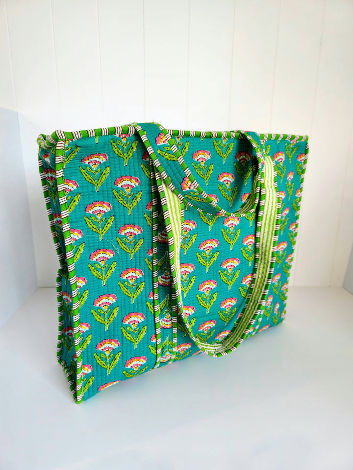 Green tote bag with floral pattern on a white background