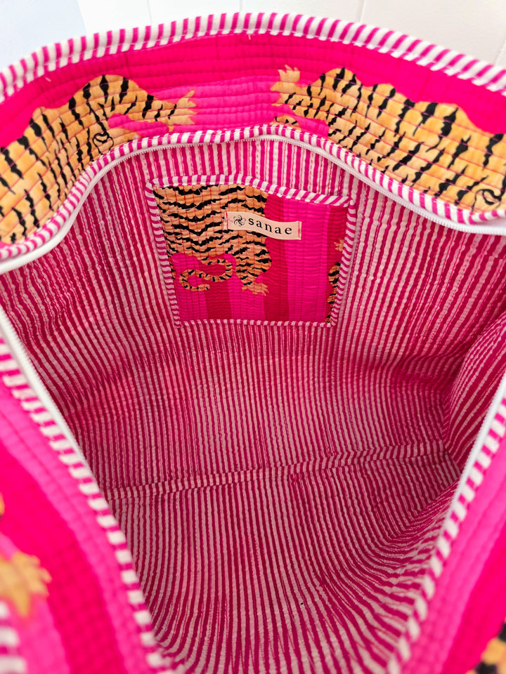 Close-up of a pink garment with tiger pattern and brand label.