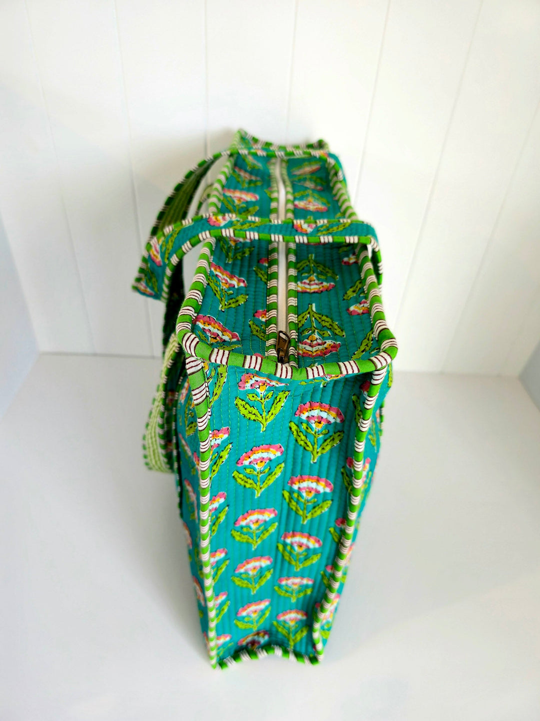 Green patterned bag with a zipper on a white background